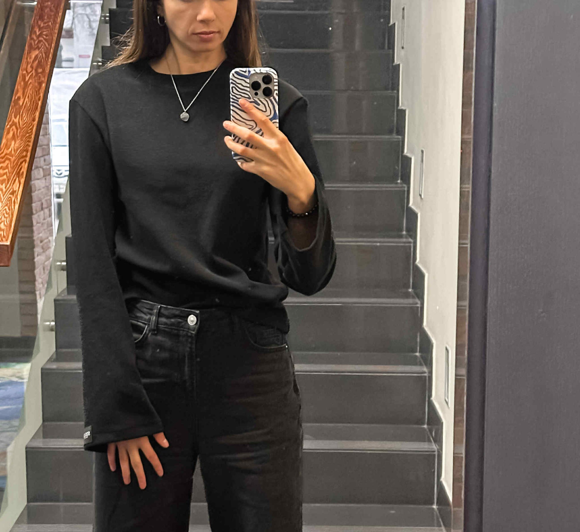 Prigludusi megzto trikotažo palaidinė ilgomis platėjančiomis rankovėmis su petukais.